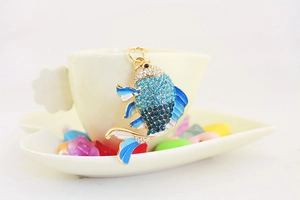 Detailaufnahme eines Goldfisch-Schlüsselanhängers mit blauen Kristallen und Emaille