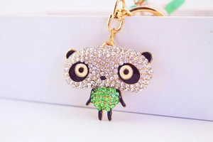 Detail of sparkling rhinestone panda keychain with green crystals and gold lobster clasp