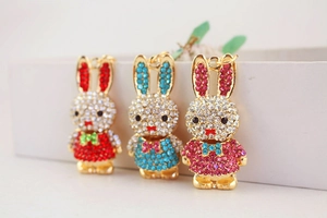 Close-up of sparkling rhinestone rabbit pendants in red, blue and pink with metal frames
