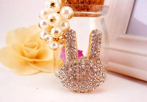 Détail d'un porte-clés lapin mignon avec strass brillants et grappe de perles crème