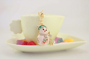 Detail of rhinestone skiing snowman keychain hanging on a cup with pearlized enamel finish