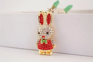 Close-up of sparkling rhinestone bunny keychain with golden plating and red crystal dress