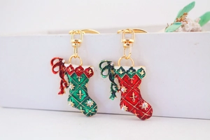 Close-up of red and green Christmas stocking keychains with rhinestone and enamel detail
