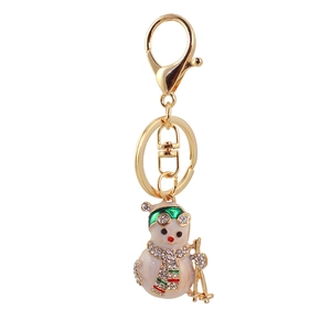 Sparkling rhinestone Christmas snowman keychain in gold metal with white enamel finish