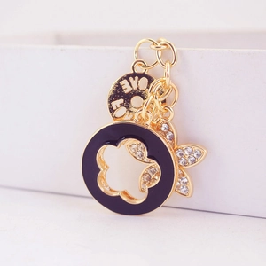 Golden four-leaf clover keychain with purple enamel ring, rhinestones, and LOVE tag