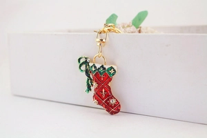 Close-up of red enamel Christmas stocking keychain with sparkling rhinestones and gold clasp
