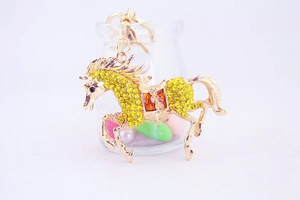 Detailed close-up of golden horse keychain with yellow crystals and lobster clasp