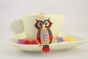 Detail van uil sleutelhanger met glinsterende strass-steentjes en gekleurd emaille aan ring