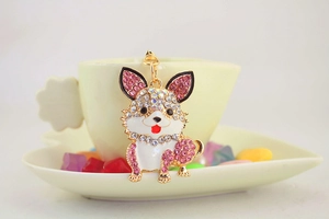 Detailansicht eines Strass-Corgi-Schlüsselanhängers an einer cremefarbenen Tasse