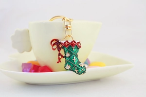 Detailed close-up of a Christmas stocking keychain with green red enamel and rhinestones