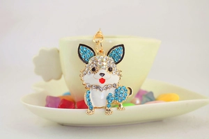 Nahaufnahme eines goldenen Corgi-Schlüsselanhängers mit blauen Strasssteinen am Tassenrand