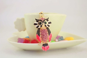 Detail van de uil sleutelhanger met roze strass steentjes hangend aan een koffiekop
