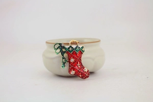 Detail of Christmas stocking keychain with red enamel, green bow, and rhinestones