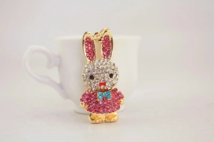 Detailed view of rhinestone rabbit keychain with pink crystals on white cup