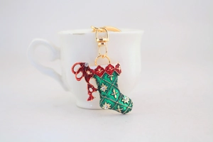 Detailed view of Christmas stocking keychain with rhinestones on a white cup