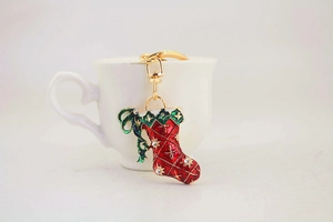 Detailed close-up of a Christmas boot keychain with red enamel and sparkling rhinestones