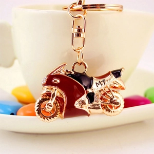 Portachiavi moto rosso in lega dorata con strass e pietre colorate sullo sfondo