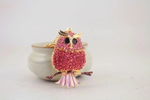 Detailed close-up of pink and red rhinestone owl keychain with golden metal hooks