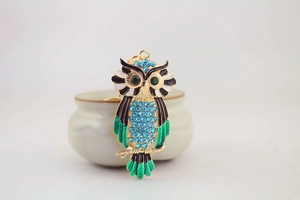 Detailed macro view of colorful rhinestone owl keychain with green enamel and gold plating