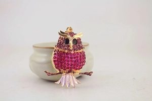 Close-up of owl keychain with sparkling magenta rhinestones and golden metal details