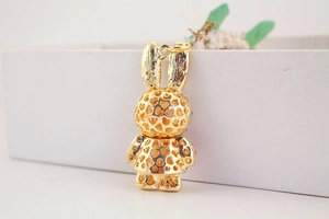 Macro side view of golden hollow-out heart pattern rabbit pendant for keychains