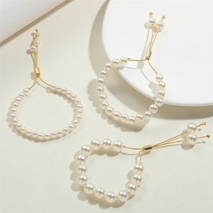 Elegant 14K gold plated pearl drawstring rings with adjustable chains on a stone stand