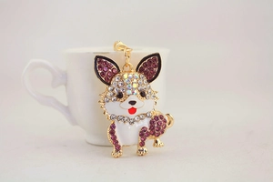 Nahaufnahme der goldenen Hunde-Schlüsselanhänger mit lila Strass und Emaille-Details