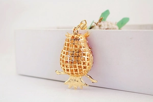 Detail of owl keychain back view featuring golden honeycomb hollow craft and metal ring