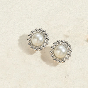 Macro view of vintage silver floral base with a polished white pearl stud earring