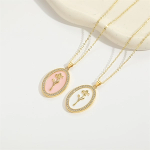 Close-up of enamel rose pendant necklaces with sparkling crystals and golden chain