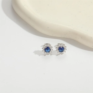 Elegant sunburst stud earrings with blue sapphire zircon center and white halo