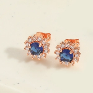 Macro view of sunflower earrings with deep blue zircon and rose gold flower cluster