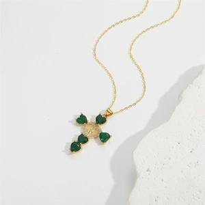 Elegant gold necklace featuring a cross pendant with green heart stones and Mary emblem