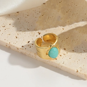 Macro detail of oval turquoise stone and woven texture on adjustable gold ring