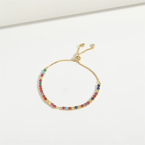 Adjustable gold bracelet with multi-color cubic zirconia gemstones on a white background