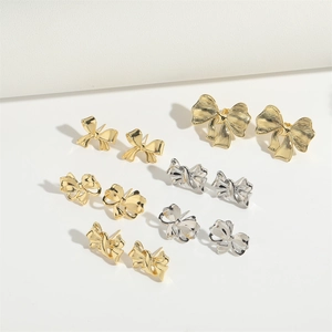 Detalle de set de 6 pares de pendientes de lazo dorados y plateados con texturas