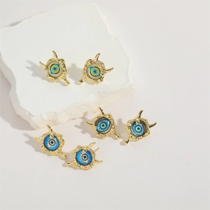 Golden copper stud earrings featuring colorful resin evil eye designs on white stone
