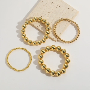 Set van 4 luxe gouden kralenarmbanden met een gepolijst spiegelend metalen oppervlak