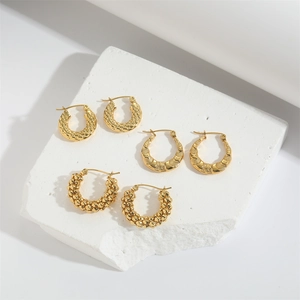 Tres pares de pendientes de aro dorados vintage con texturas tejidas y florales