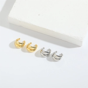 Minimalist double-layer ball ear cuffs in gold and silver finish on a white stone background