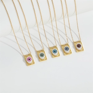 Detail view of six gold necklaces with colorful Devil's Eye pendants on a white display