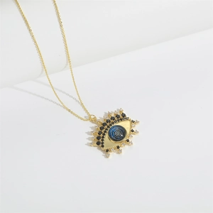 Macro shot of gold-plated Devil's Eye pendant with blue inlay and sparkling zircons