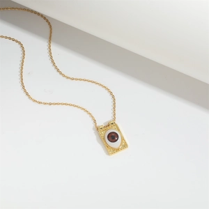Vintage gold Devil's Eye necklace with a rectangular eye pendant on a minimalist background