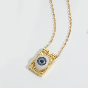 Macro detail of retro golden square pendant necklace with blue devil's eye design
