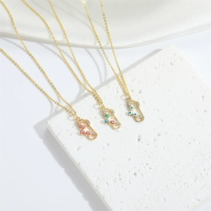 Detailed view of gold pin necklaces with blue and green evil eye zircon pendants