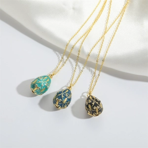 Vintage Faberge style enamel egg pendants with floral gold patterns and small zircons