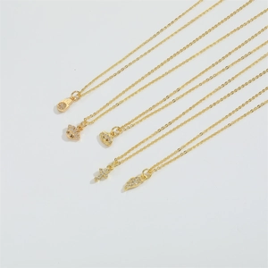 Macro de cinq colliers dorés avec pendentifs Hamsa, mauvais œil et croix sertis de zircons