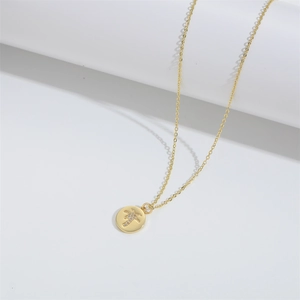 Macro shot of gold palm tree pendant with cubic zirconia on a minimalist white stand