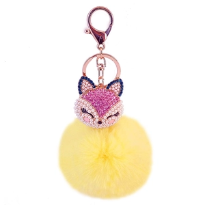 Detail of pink rhinestone fox keychain with yellow fur ball and rose gold metal clasp
