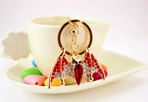 Detailed close-up of a gold-plated bat keychain with sparkling red and white crystals